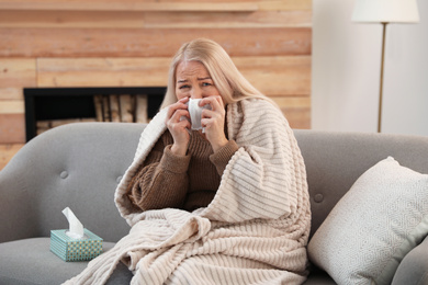 Photo of Mature woman suffering from cold at home. Dangerous virus