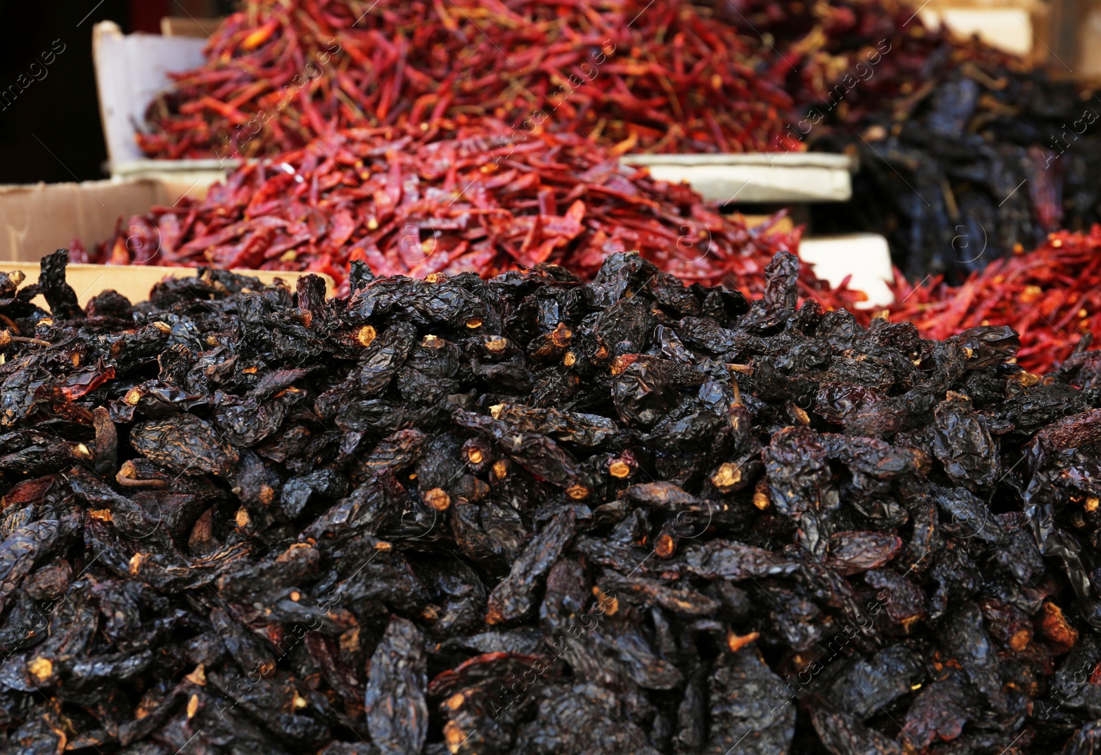Photo of Heap of dried Ancho chile peppers on counter at market