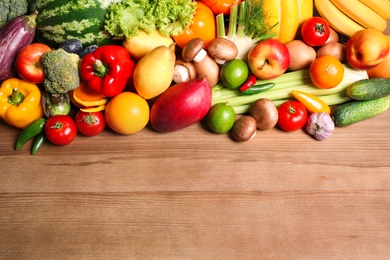 Photo of Assortment of fresh organic fruits and vegetables on wooden table, flat lay. Space for text