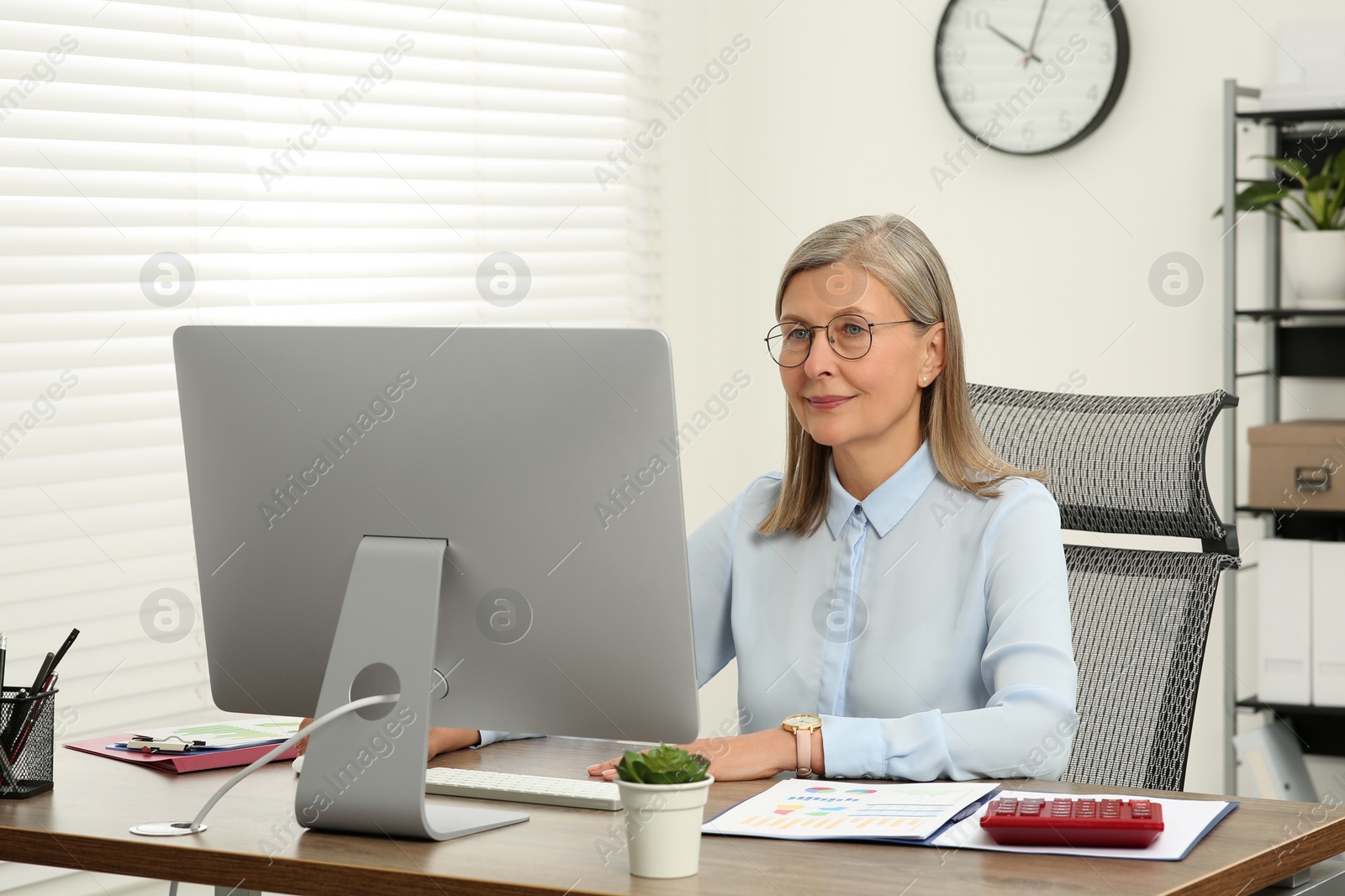 Photo of Senior accountant working at wooden desk in office