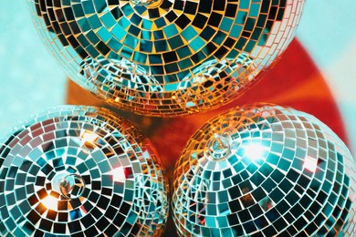 Bright shiny disco balls on color background, top view
