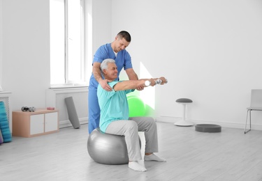 Photo of Professional physiotherapist working with senior patient in rehabilitation center