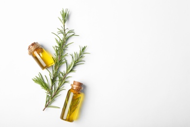 Photo of Composition with bottles of rosemary oil on white background, top view