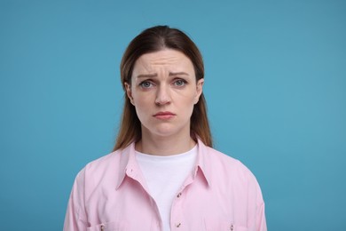 Photo of Portrait of sad woman on light blue background
