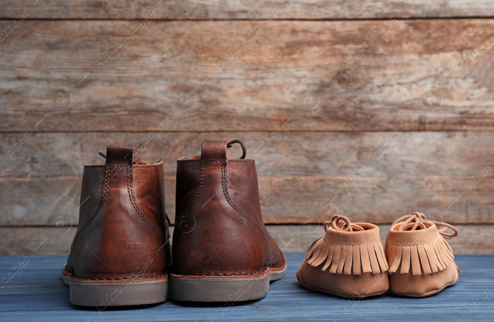 Photo of Big and small shoes on wooden background. Father's day celebration