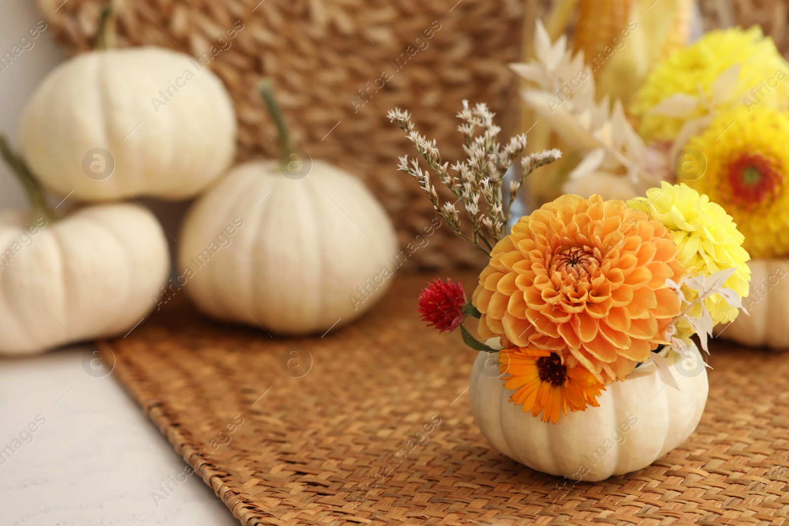 Photo of Small pumpkin with autumn bouquet on table, selective focus