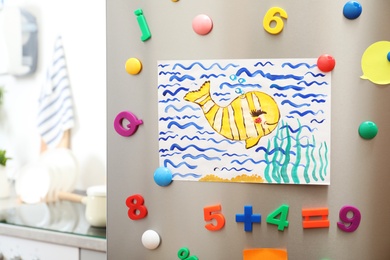 Child's drawing and magnets on refrigerator door in kitchen