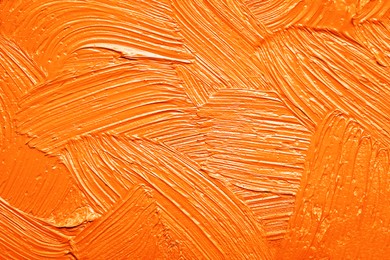 Image of Strokes of orange oil paint as background, closeup