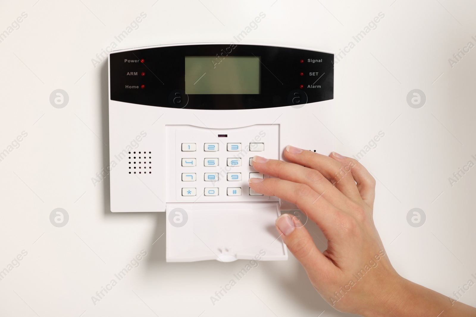 Photo of Woman entering code on home security system, closeup