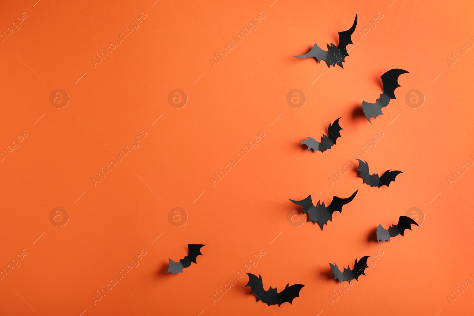 Photo of Paper bats on orange background, flat lay with space for text. Halloween decor