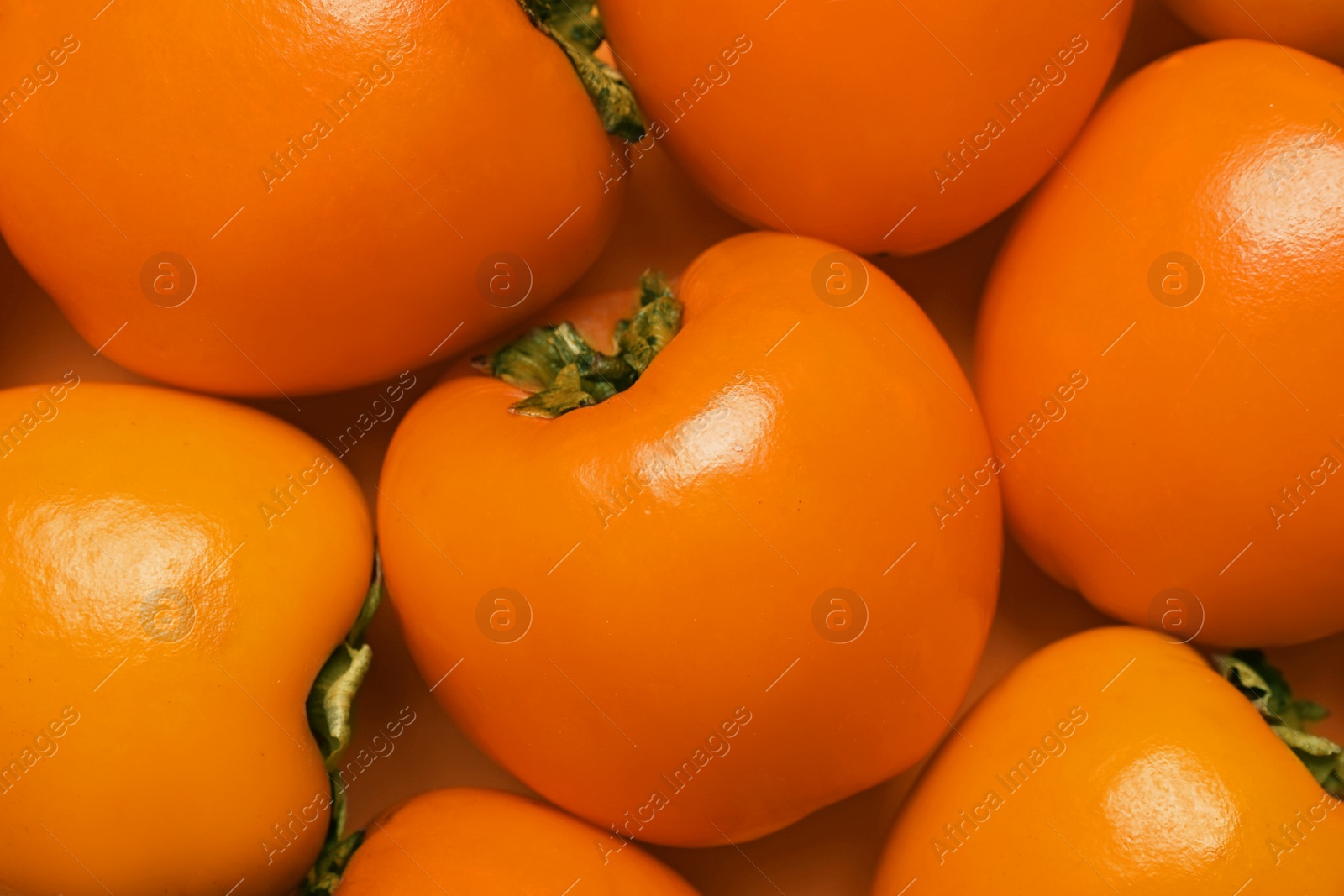 Photo of Delicious ripe juicy persimmons as background, top view