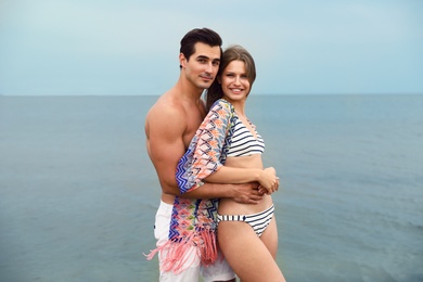 Photo of Happy young couple spending time together on sea beach