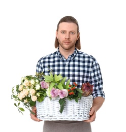 Male florist holding basket with flowers on white background