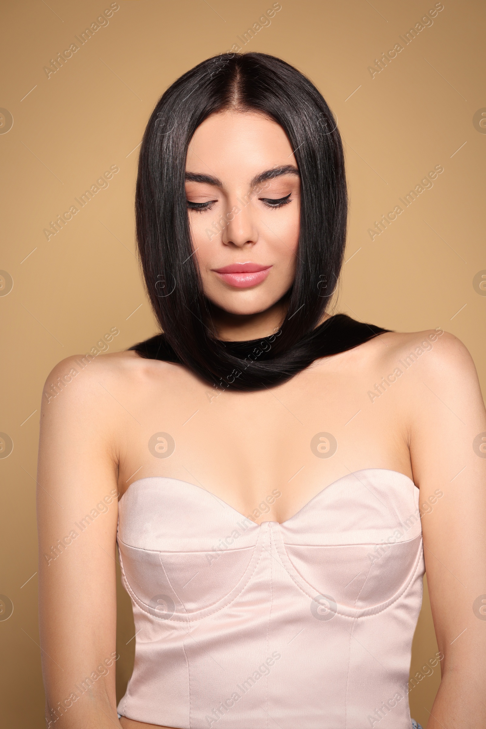 Photo of Portrait of beautiful young woman with healthy strong hair on beige background