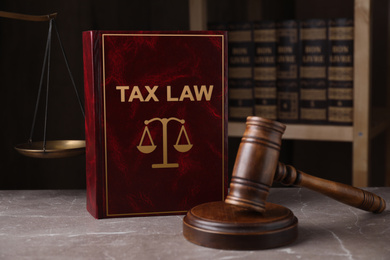 Image of Tax law book and gavel on grey marble table