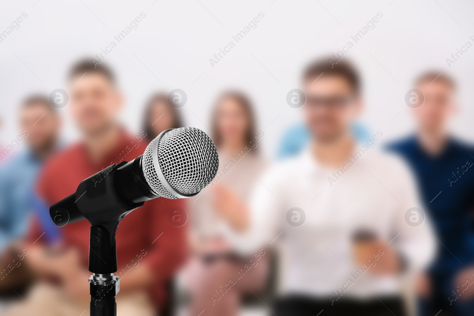 Image of Modern microphone and people at business training indoors, closeup