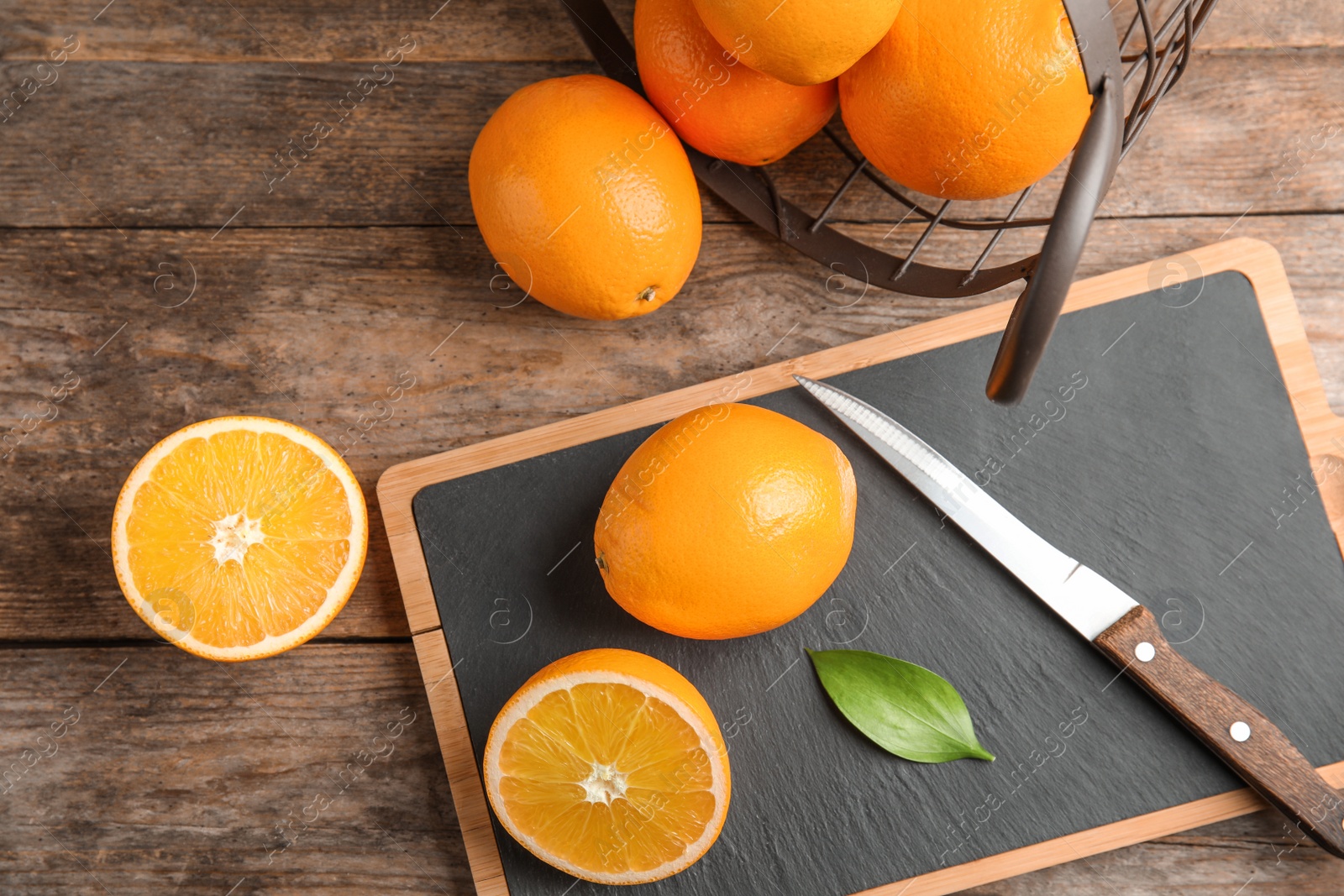 Photo of Fresh juicy oranges on wooden table, top view