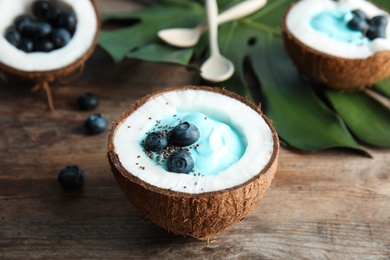 Photo of Coconut with spirulina smoothie on wooden table