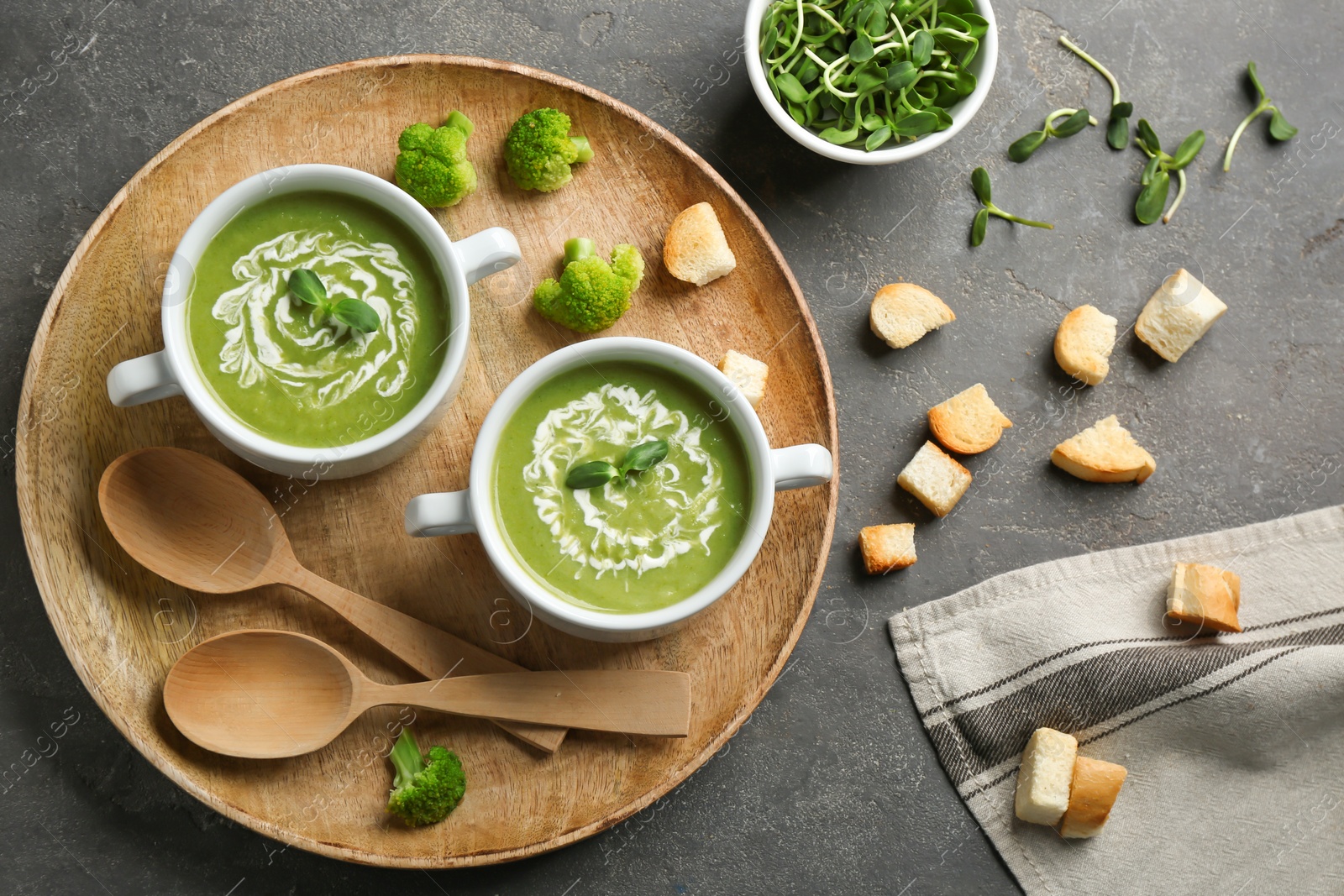 Photo of Flat lay composition with bowls of broccoli cream soup on grey table