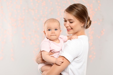 Photo of Portrait of happy mother with her baby against blurred lights. Space for text
