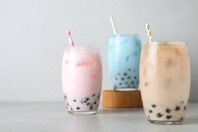 Different milk bubble teas on light grey table