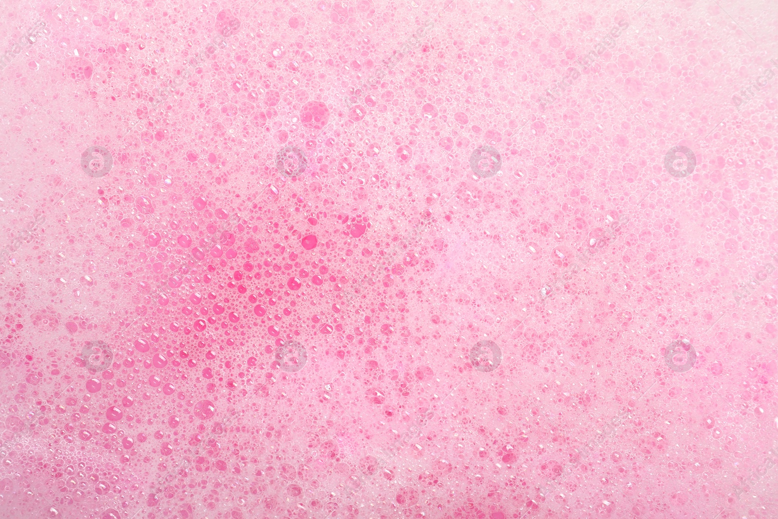 Photo of Colorful foam after dissolving bath bomb in water, closeup