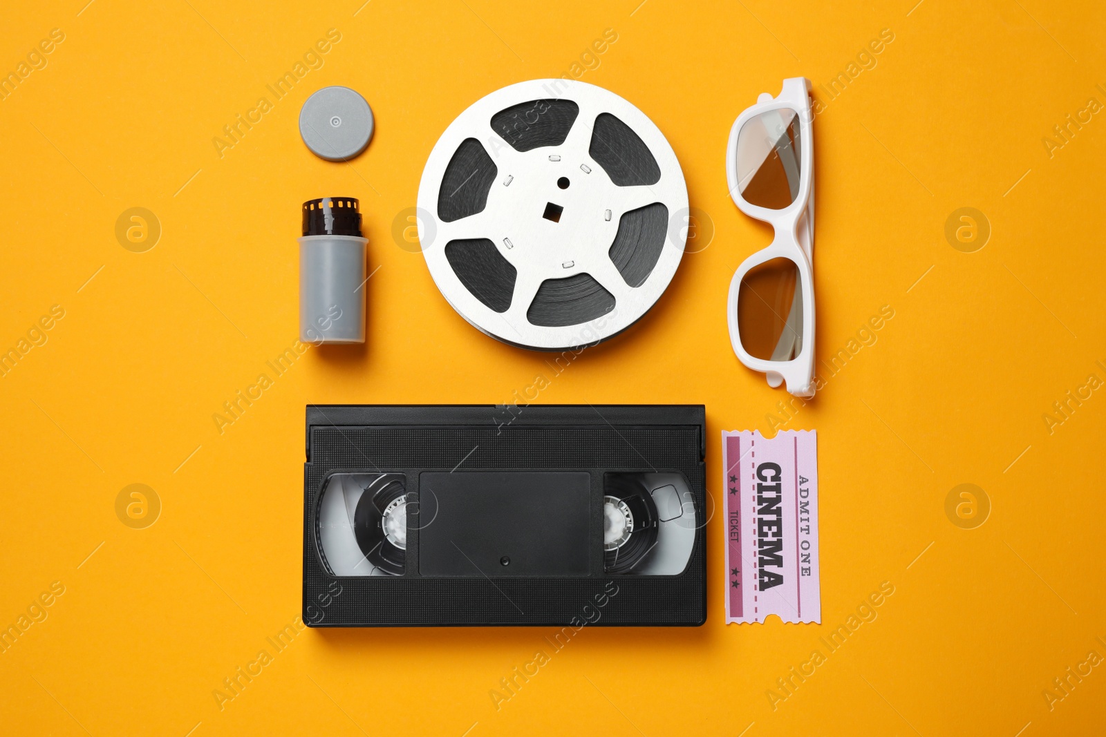 Photo of Flat lay composition with film reel and cinema ticket on orange background