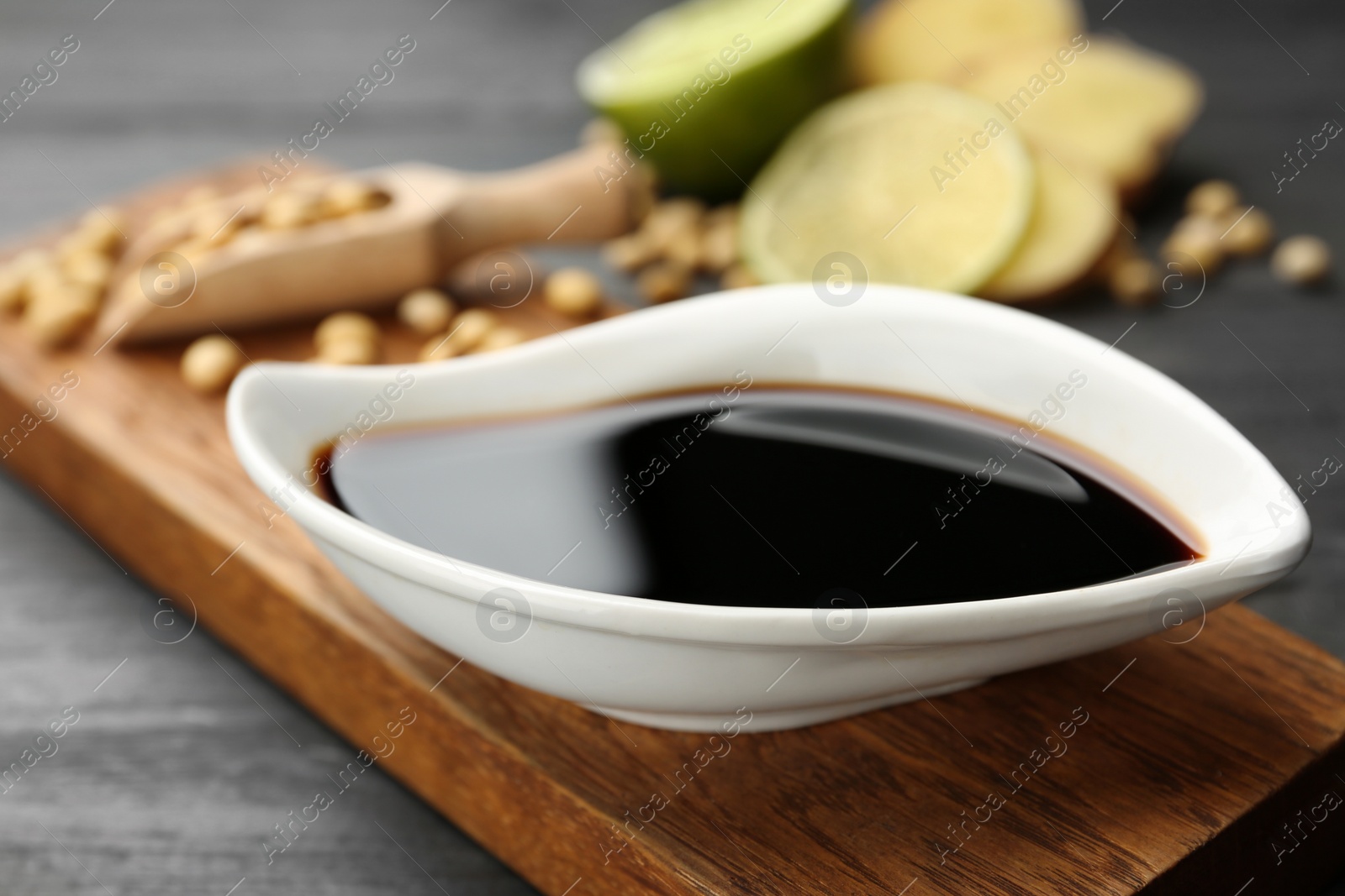 Photo of Board with dish of soy sauce on table, closeup