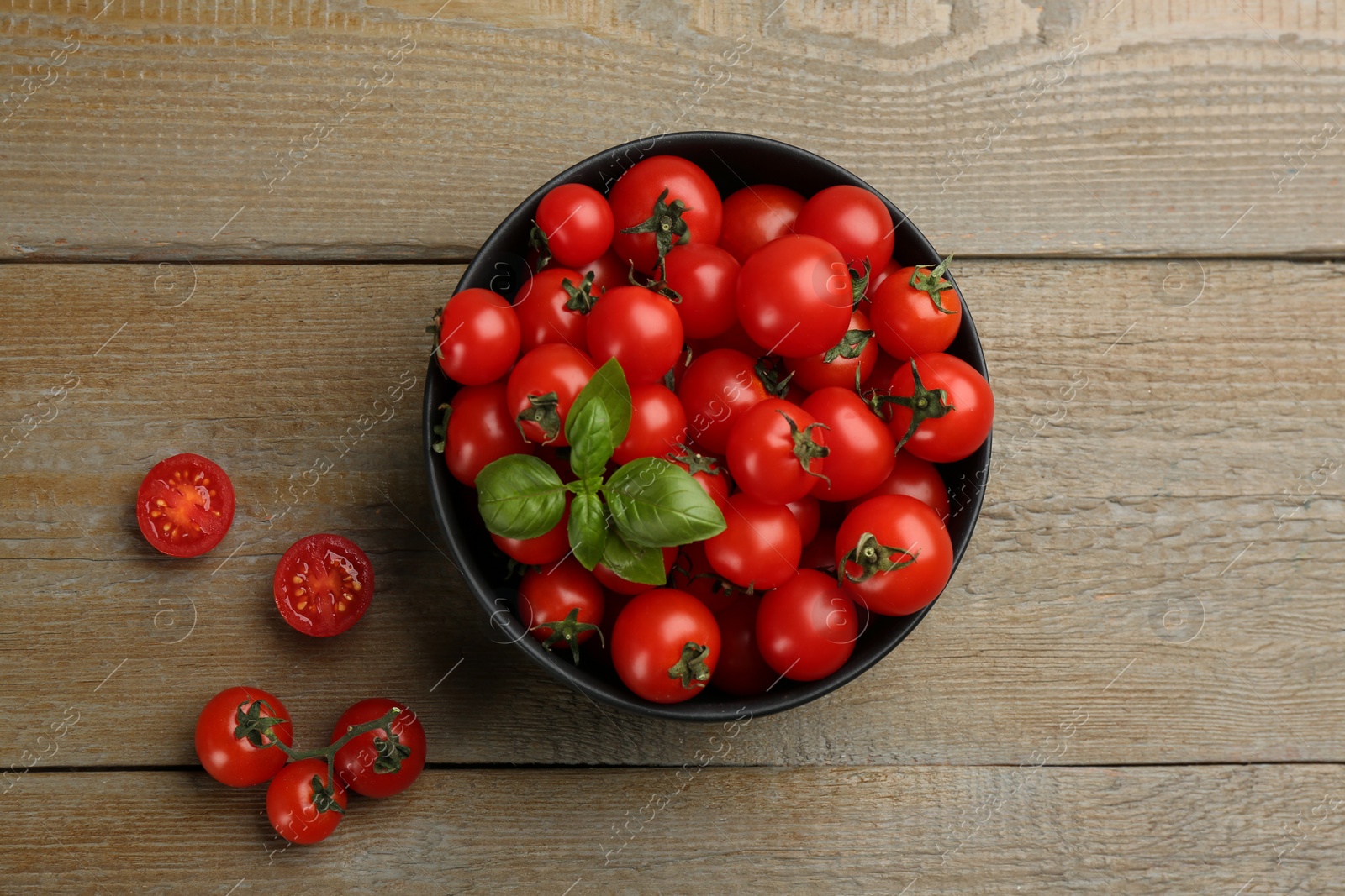 Photo of Fresh cherry tomatoes and basil leaves on wooden table, flat lay