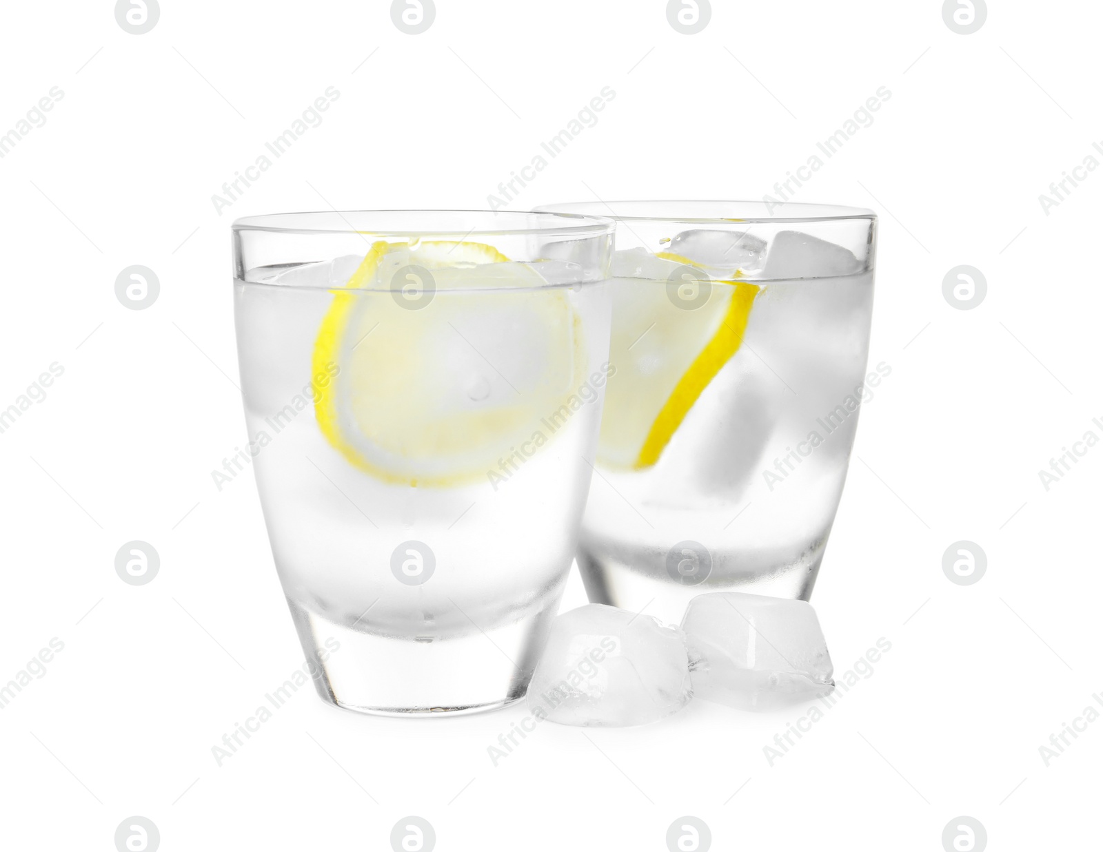Photo of Shot glasses of vodka with lemon slices and ice on white background