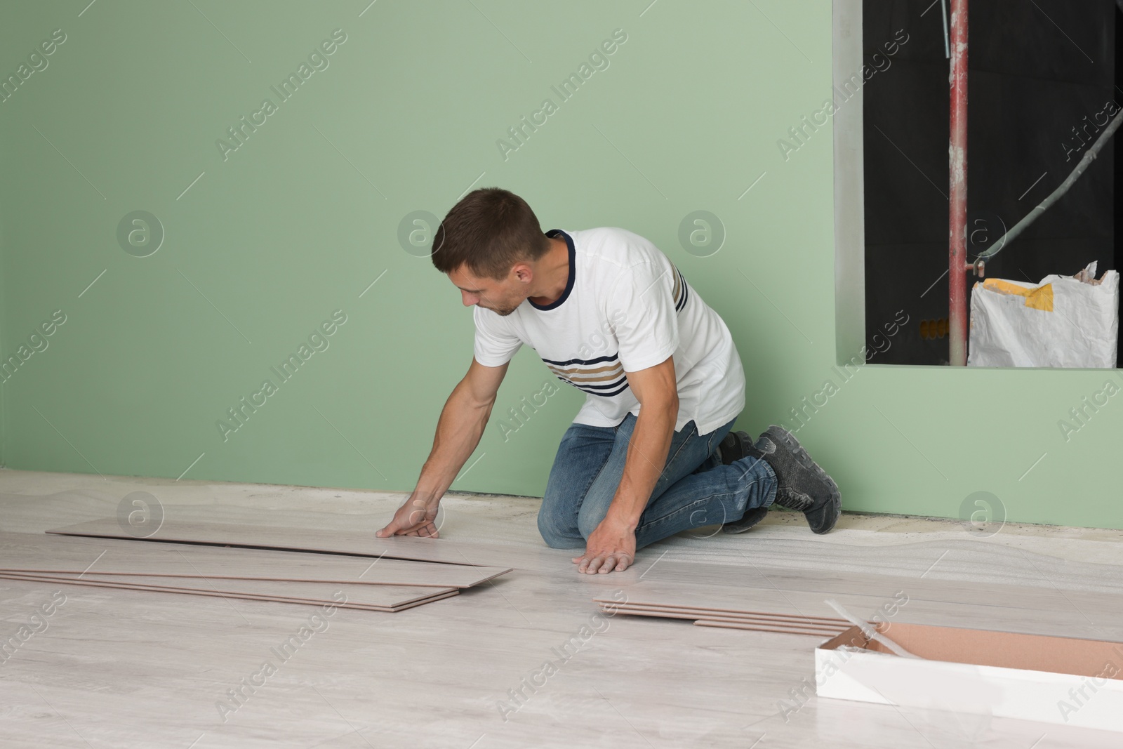 Photo of Man installing new laminate flooring in room