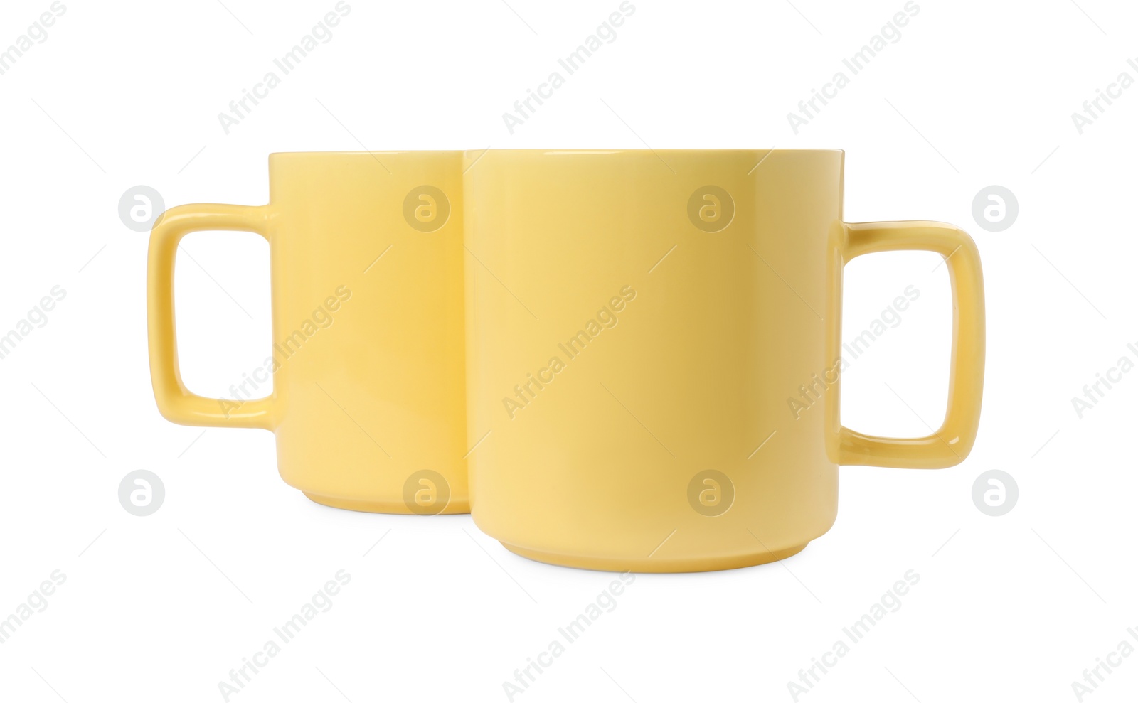 Photo of Two yellow ceramic mugs isolated on white