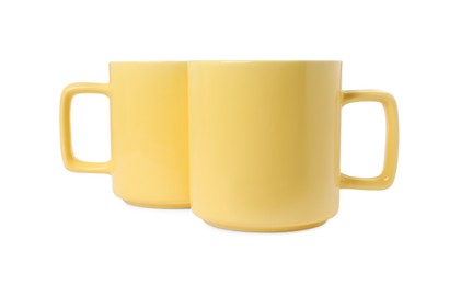 Two yellow ceramic mugs isolated on white