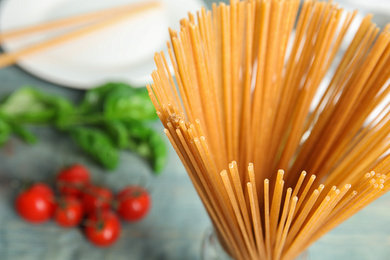 Photo of Uncooked buckwheat noodles on blue wooden table, closeup