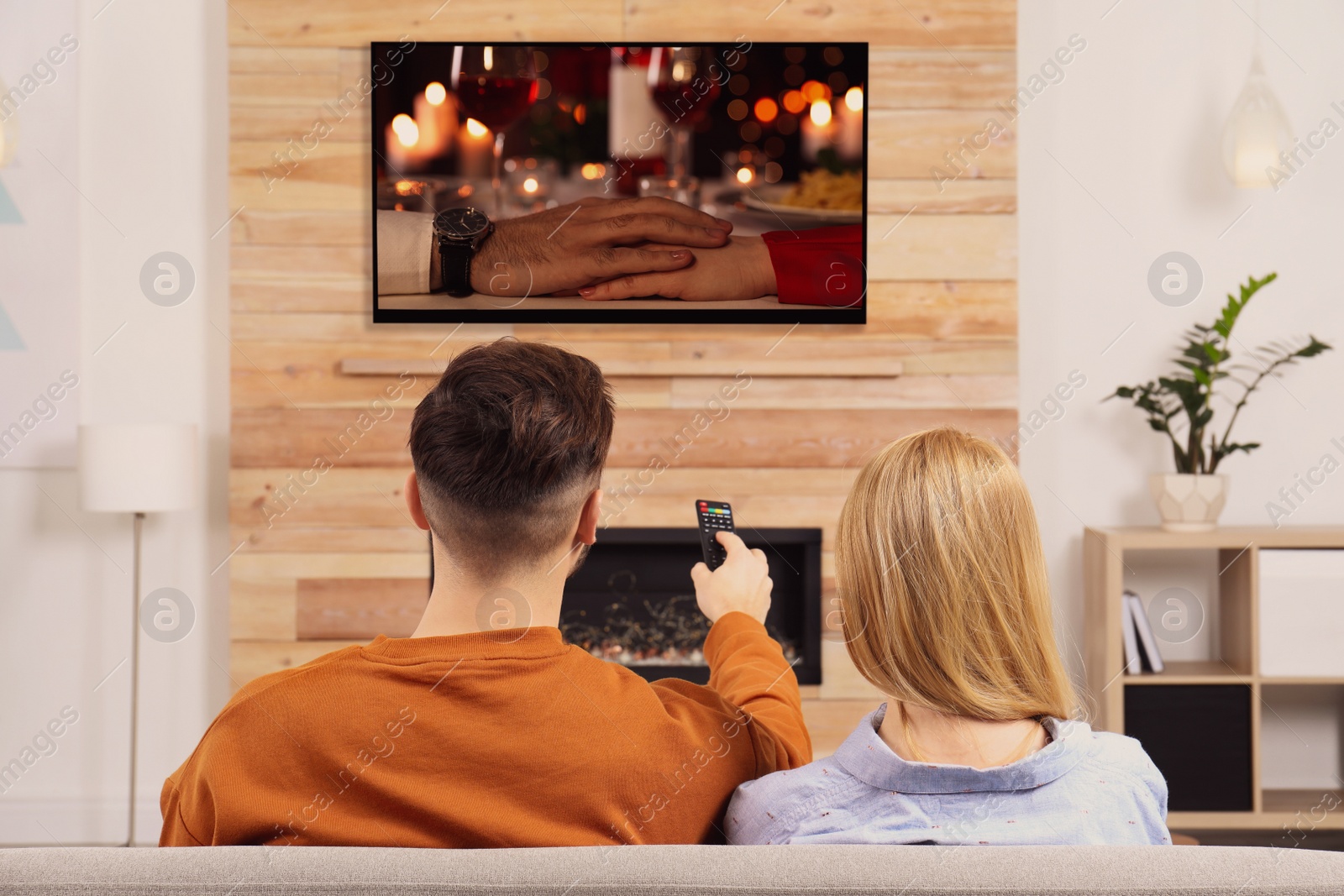 Image of Couple watching romantic movie on TV in living room