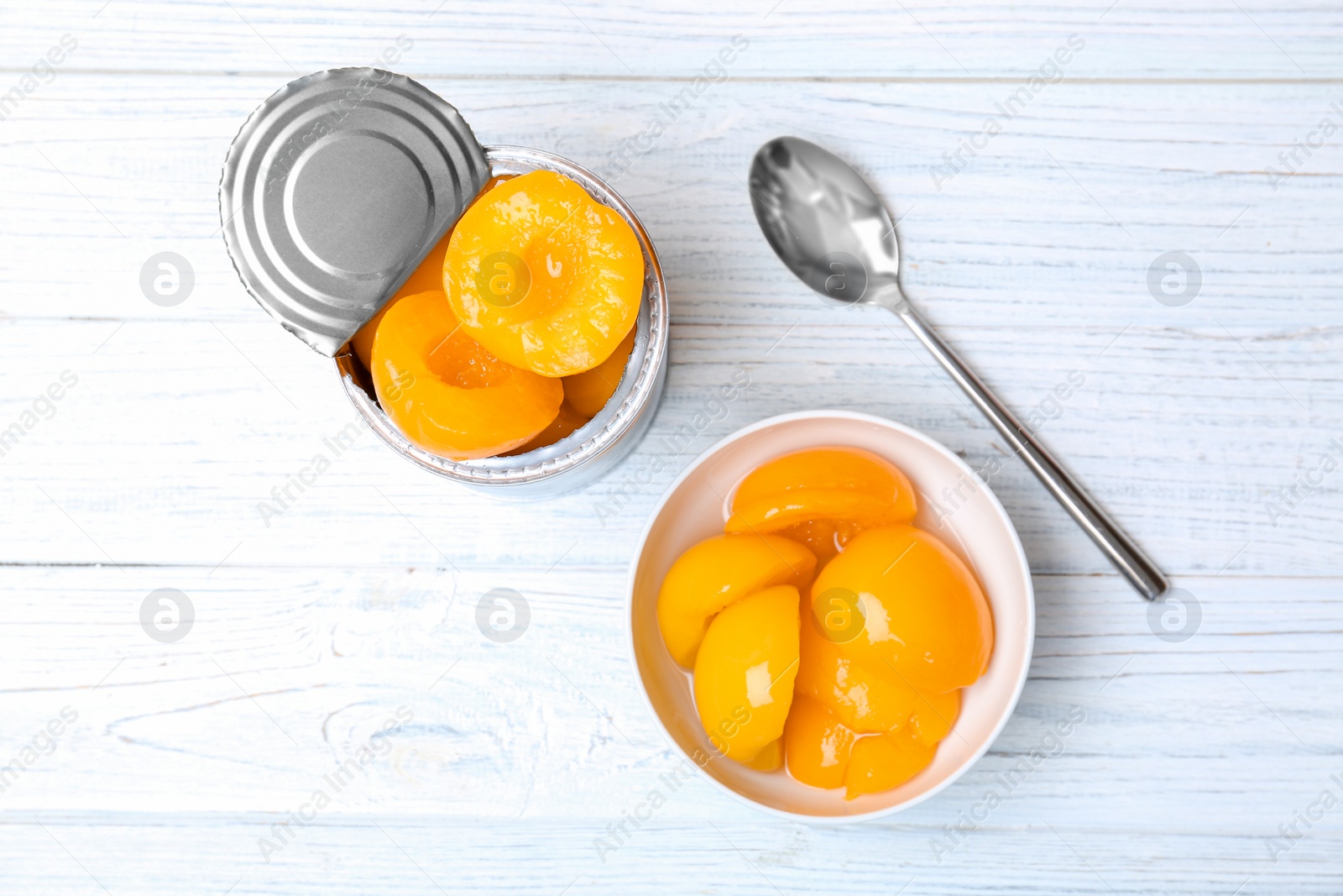 Photo of Flat lay composition with canned peaches on wooden background