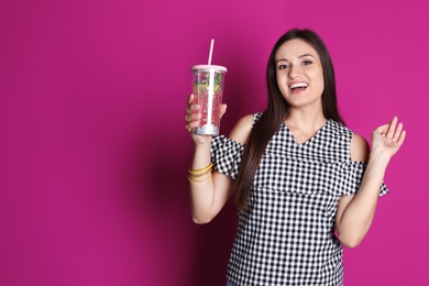 Photo of Young woman with tasty lemonade on color background. Natural detox drink