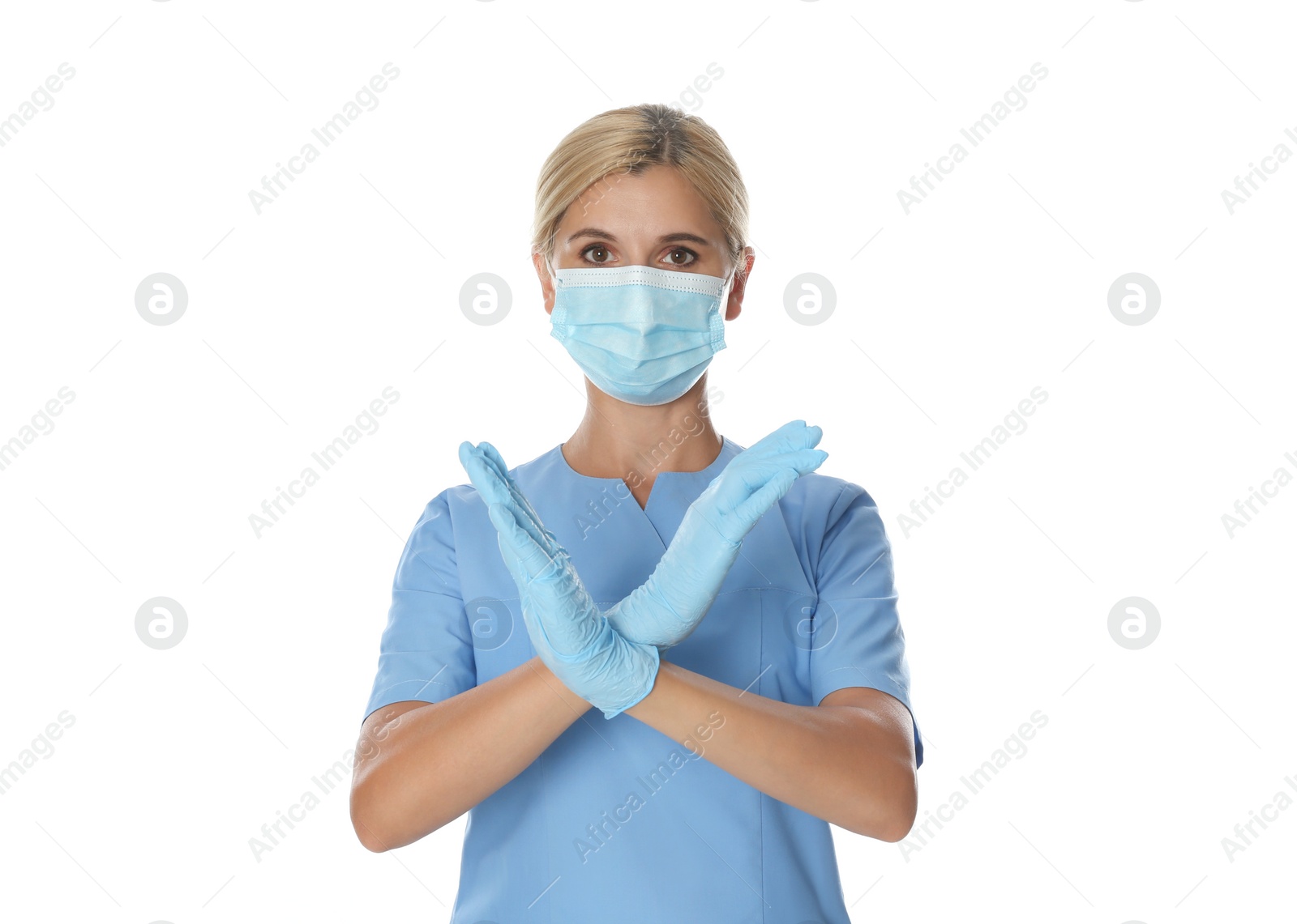 Photo of Doctor in protective mask showing stop gesture on white background. Prevent spreading of coronavirus