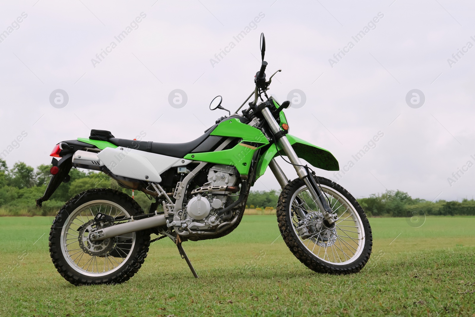 Photo of Stylish cross motorcycle on green grass outdoors