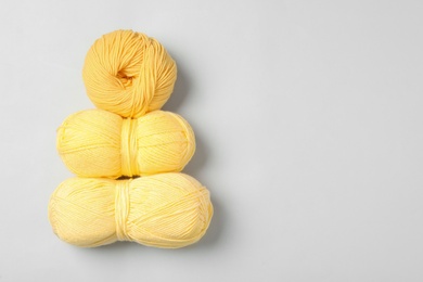 Soft woolen yarns on white background, flat lay. Space for text
