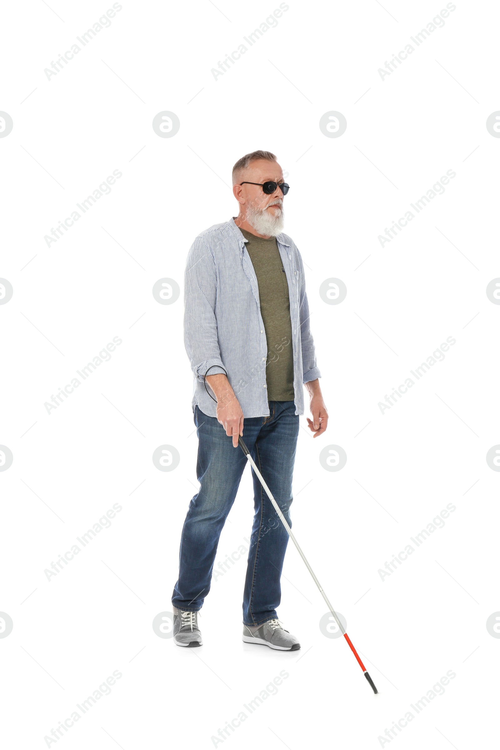 Photo of Mature blind person with long cane walking on white background