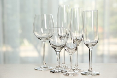 Photo of Different elegant empty glasses on grey table indoors