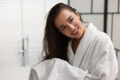Photo of Smiling woman drying hair with towel after shower in bathroom. Space for text