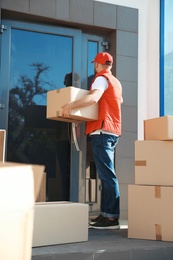Male mover with parcel box near entrance