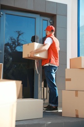 Photo of Male mover with parcel box near entrance