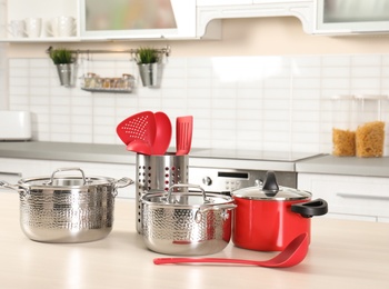 Set of clean cookware and utensils on table in kitchen