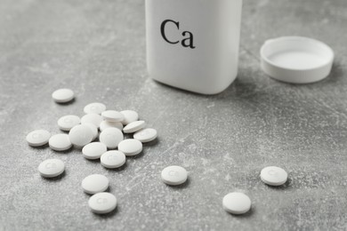 Pile of calcium supplement pills on grey table