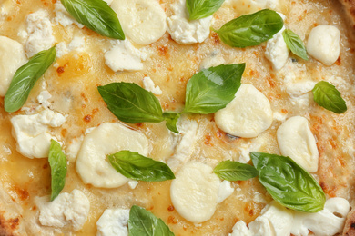 Delicious hot cheese pizza with basil as background, top view