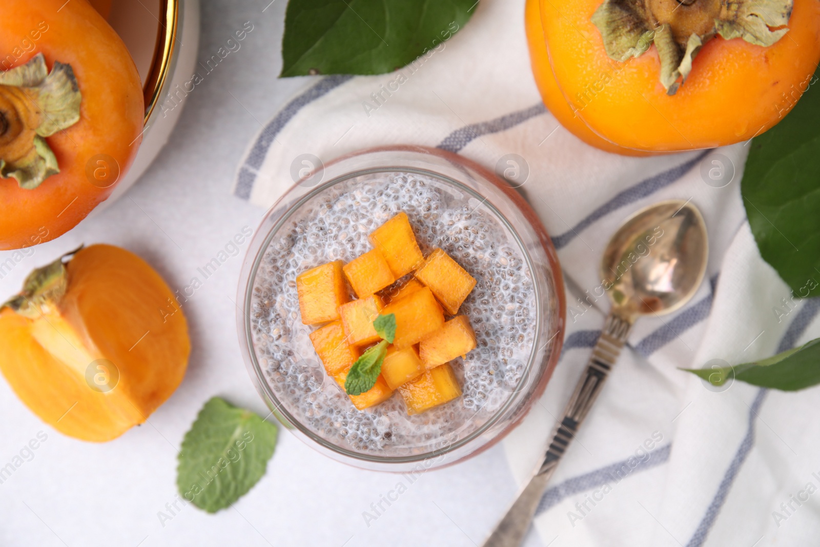 Photo of Delicious dessert with persimmon and chia seeds on table, flat lay
