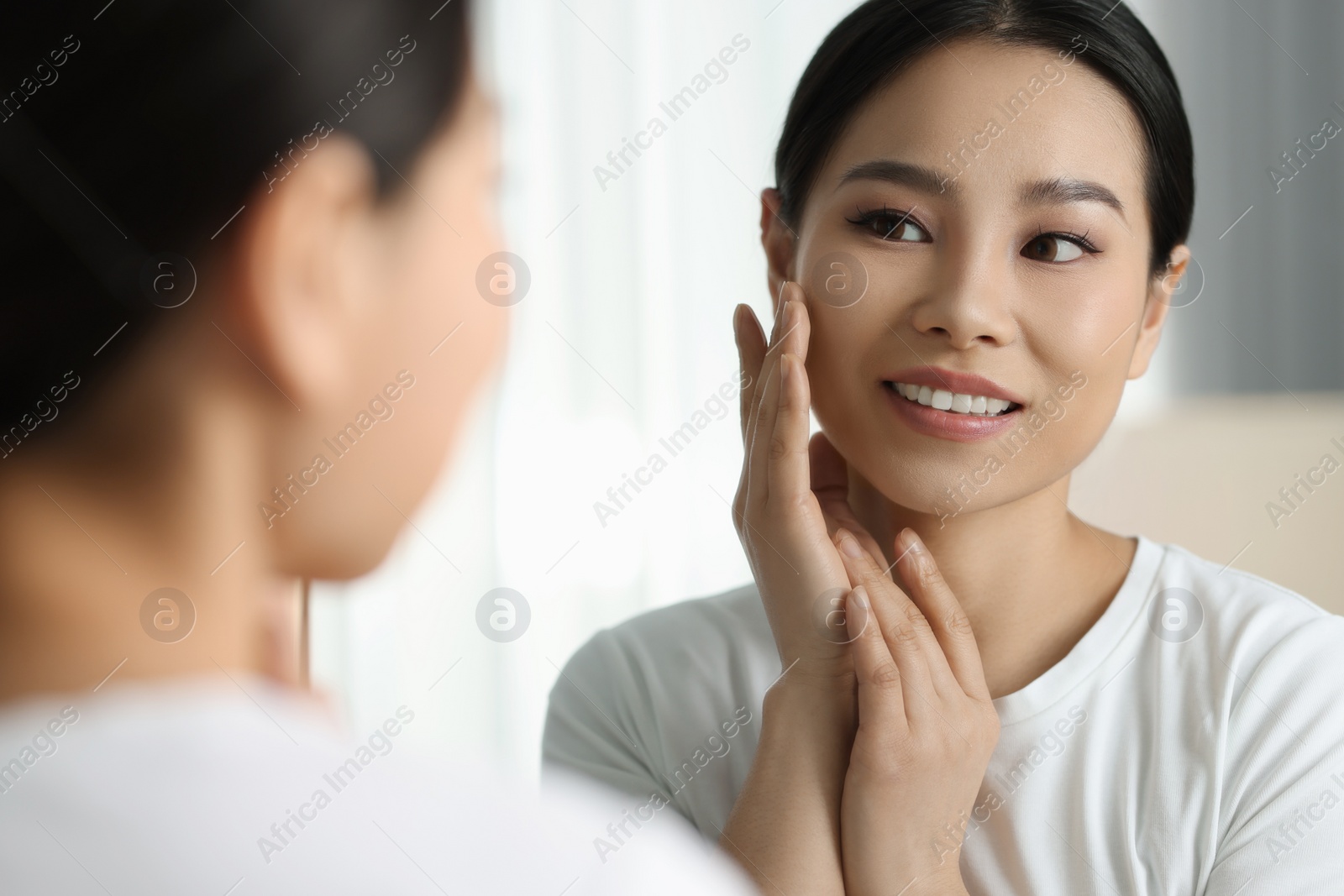 Photo of Portrait of beautiful woman near mirror indoors